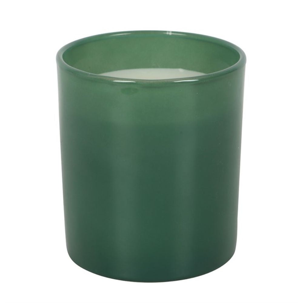 Green candle in a cylindrical container on a white background