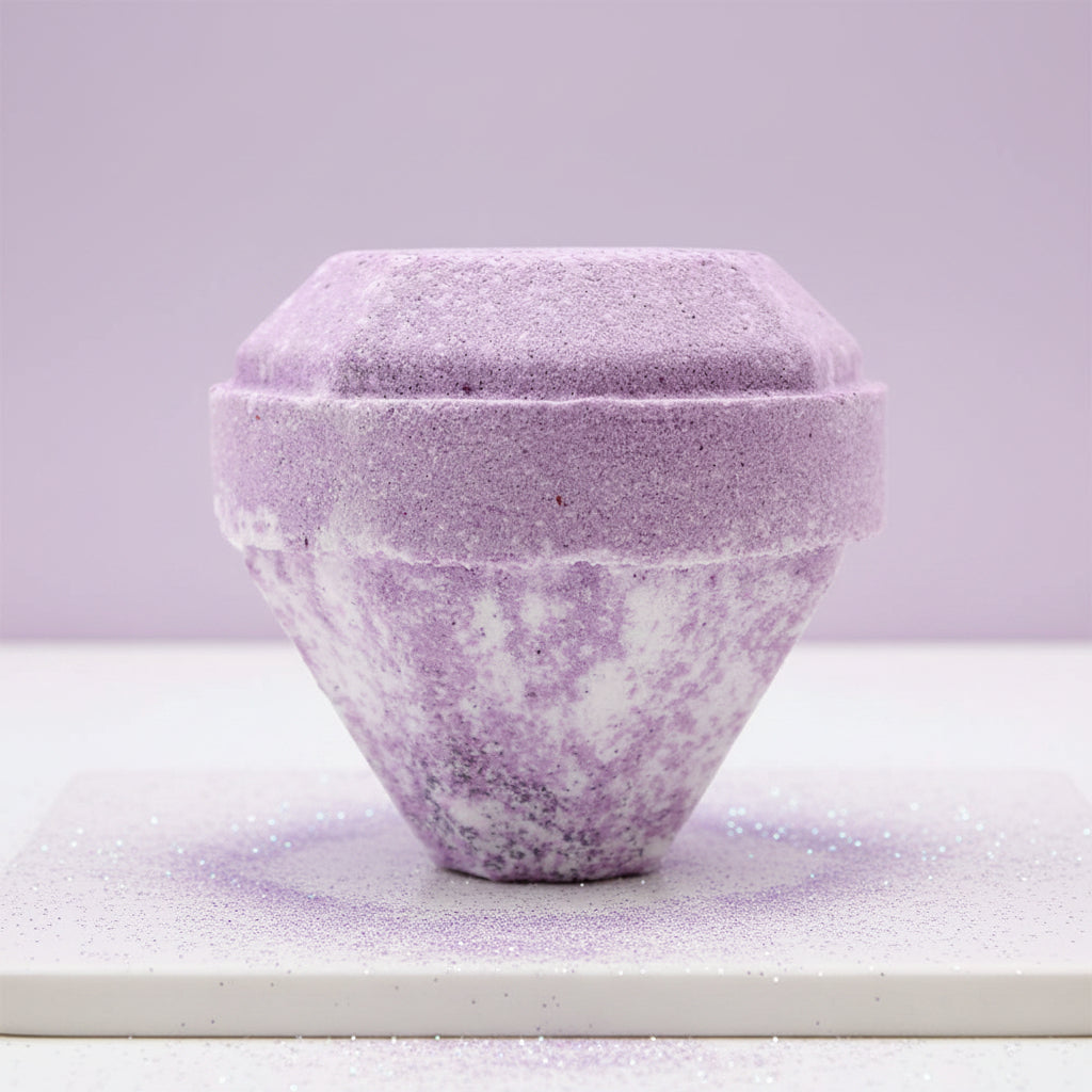 A lilac and white bath bomb with a genuine gemstone inside.