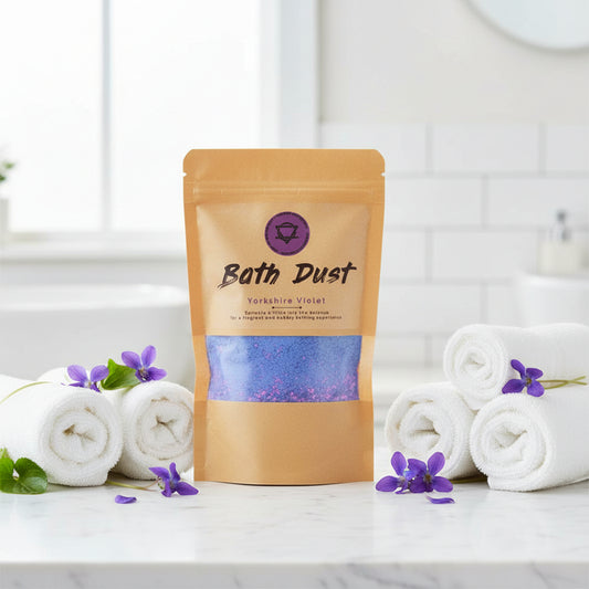 A package of Bath Dust bath add-in with shea butter, displayed in a clear window showing the product inside.