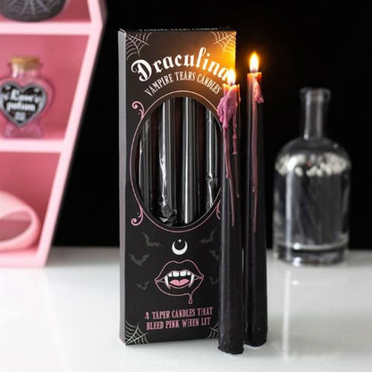 Black candles with pink interior in a decorative box labeled 'Draculina Vampire Tears Candles' on a white surface.