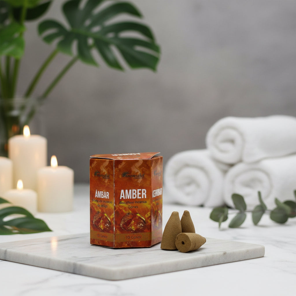 A box of Aromatika Backflow Incense Cones with the label 'AMBER' and a visual representation of the cones in a natural brown color outside the box.