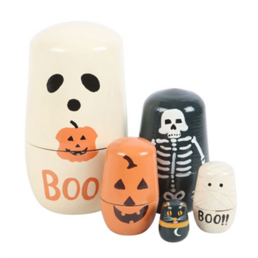 A set of five Halloween-themed nesting wooden dolls on a plain white background. The dolls are cream-colored, black, and orange, decorated with spooky illustrations like a ghost face, a pumpkin, a skeleton, a cat in a hat, and the word 'BOO'.