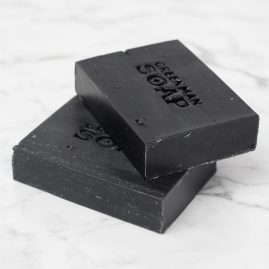 Two bars of black soap stacked on a white background with 'Greenman Soap' branding.