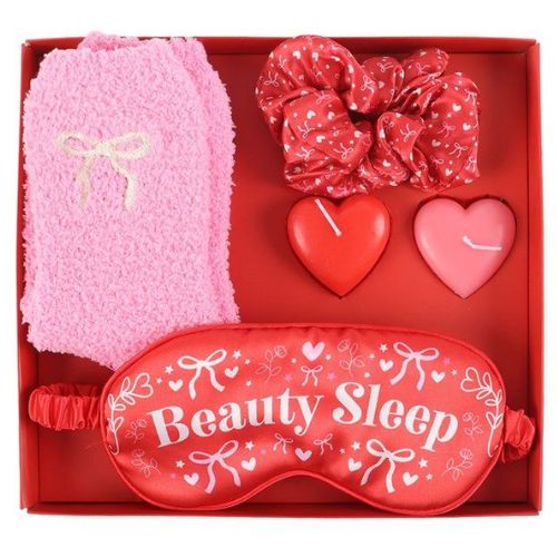 Set of beauty sleep products including a pink eye mask, red hair ties, and heart-shaped candles in a red box.