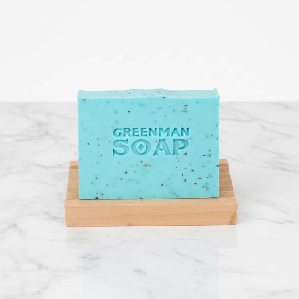 Greenman Soap bar on a wooden soap dish with a white background