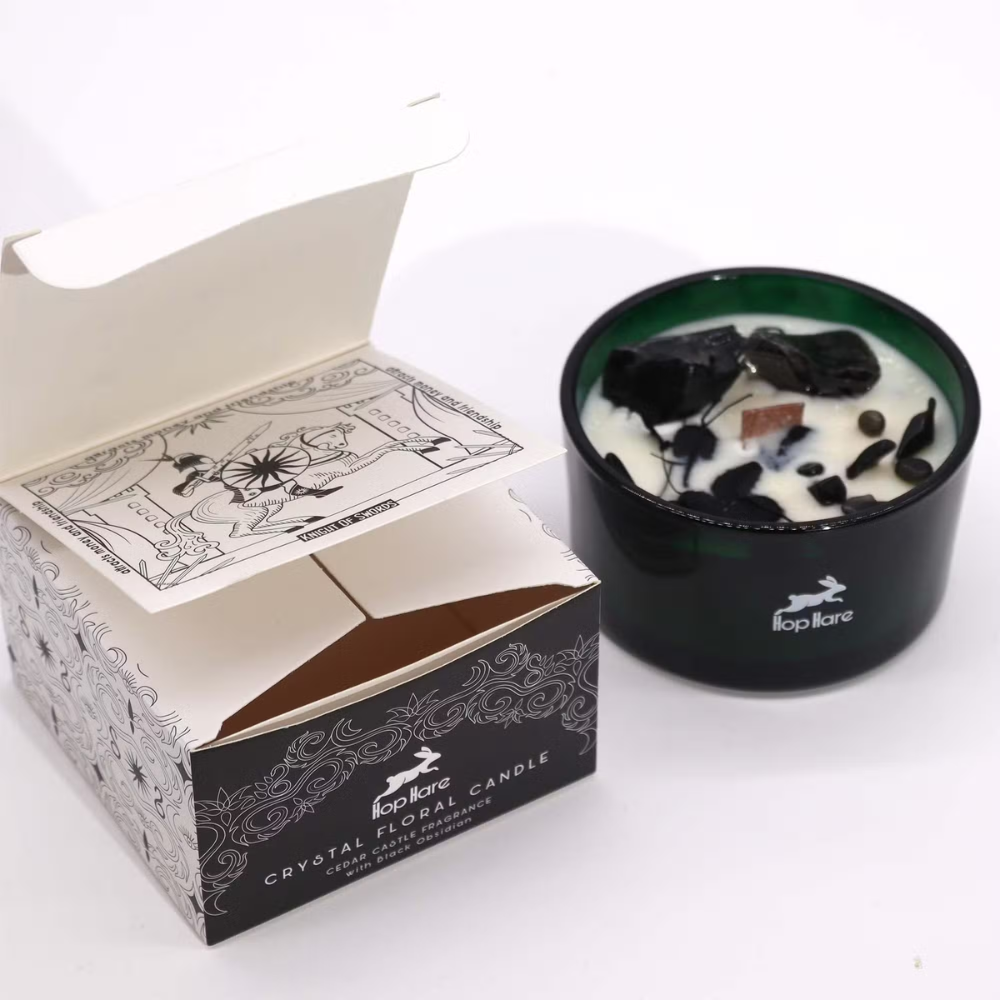 Crystal floral candle in a black holder with a decorative box on a white background