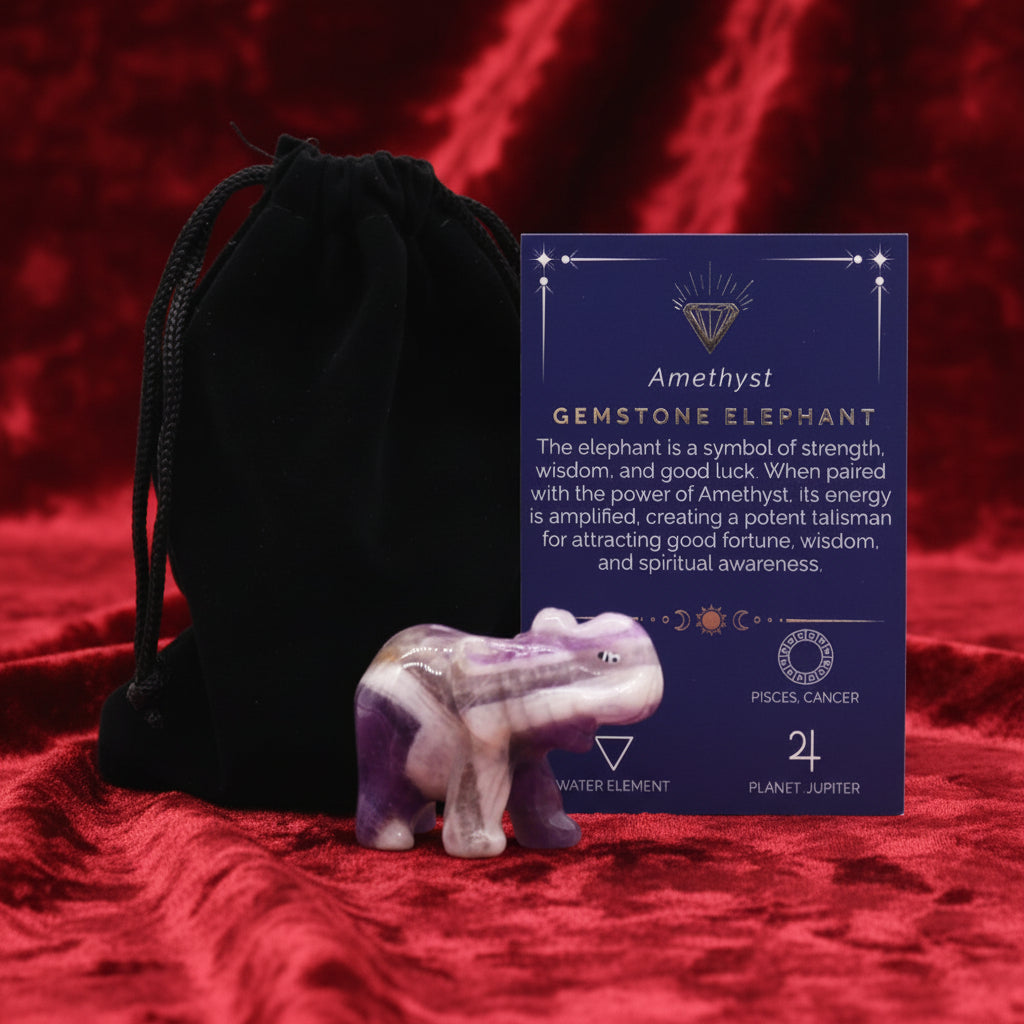 A hand-carved gemstone elephant next to a black velvet pouch and a card detailing the properties of the gemstone.