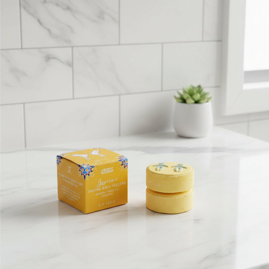 A green-colored bath fizzer with a symbol on it, next to its shrink-wrapped box with decorative patterns and the word 'Taurus' indicating it's part of a zodiac-themed set.