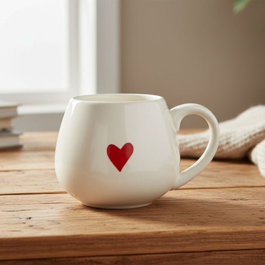 White mug with a red heart on a wooden surface